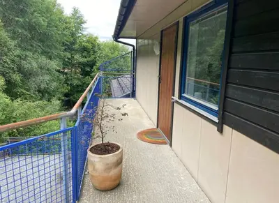a potted plant sitting on a balcony next to a window at 2 Bedroom Apartment with free parking lot in Bergen