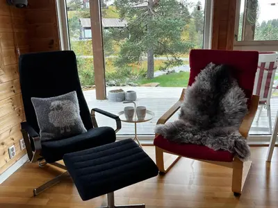 a living room with two chairs and a table at Flott familiehytte på Haukås i Strandebarm in Kvam