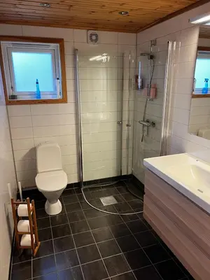 a bathroom with a toilet and a shower and a sink at Flott familiehytte på Haukås i Strandebarm in Kvam