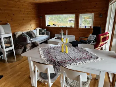 a dining room with a white table and chairs at Flott familiehytte på Haukås i Strandebarm in Kvam