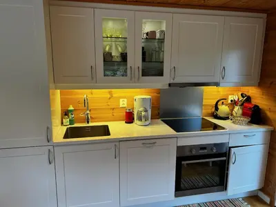 a kitchen with white cabinets and a sink at Flott familiehytte på Haukås i Strandebarm in Kvam