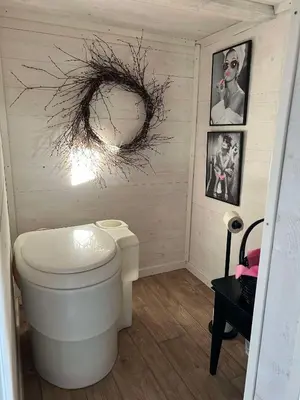 a bathroom with a toilet and a wreath on the wall at Støl ved Sognefjorden in Berge