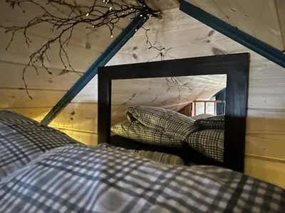a mirror in a room with a bed in a house at Støl ved Sognefjorden in Berge
