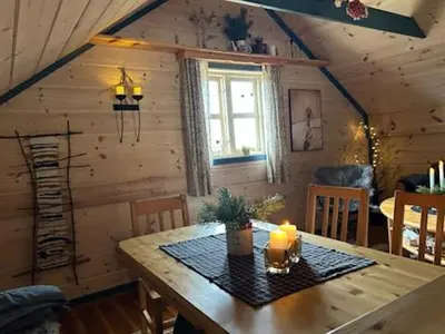 a dining room with a wooden table with candles on it at Støl ved Sognefjorden in Berge