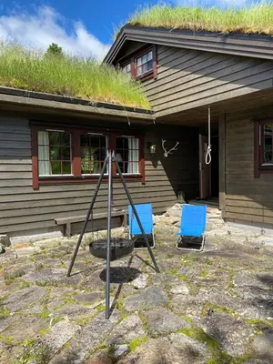 two blue chairs sitting in front of a house at Perla i Nordfjord in Emhjella