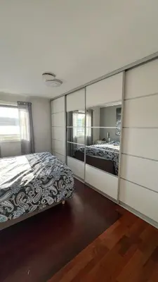 a bedroom with two beds and a large mirror at Villa with heated pool and magnificent view in Bergen