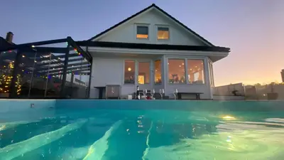a house with a swimming pool in front of a house at Villa with heated pool and magnificent view in Bergen