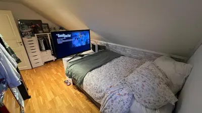 a bedroom with a bed and a flat screen tv at Villa with heated pool and magnificent view in Bergen