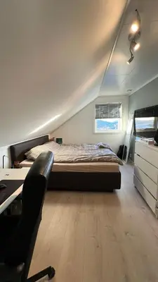 a bedroom with a bed and a desk and a chair at Villa with heated pool and magnificent view in Bergen