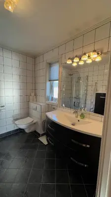 a bathroom with a tub and a sink and a toilet at Villa with heated pool and magnificent view in Bergen