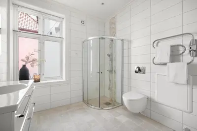 a bathroom with a shower and a toilet and a sink at Scandinavian Luxury in Bergen's Finest Street in Bergen