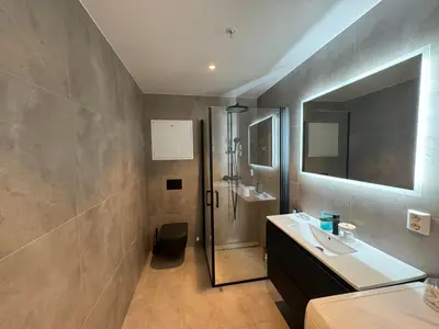 a bathroom with a sink and a shower at Modern, brand-new apartment in the heart of Bergen in Bergen