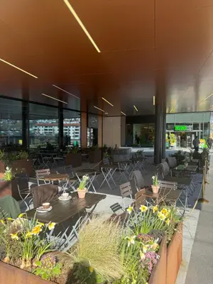 a lobby with tables and chairs in a building at Modern, brand-new apartment in the heart of Bergen in Bergen