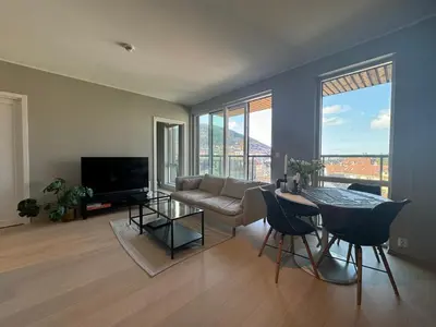 a living room with a couch and a table at Modern, brand-new apartment in the heart of Bergen in Bergen