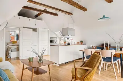 a kitchen and living room with a table and chairs at Design Apartment by Bryggen - View & Location in Bergen