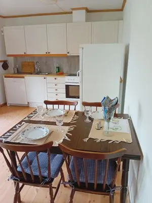 a kitchen with a wooden table with four chairs and a tableablish at Sandeidfjorden overnatting in Sandeid