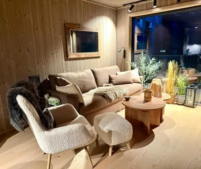 a living room with a couch and two chairs at Modern and practical ski in & out apartment in Kyrkjebøen