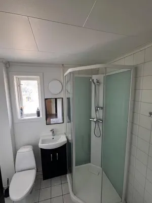a bathroom with a shower and a toilet and a sink at Trolltunga Apt for up to 5 people with balcony in Tysso