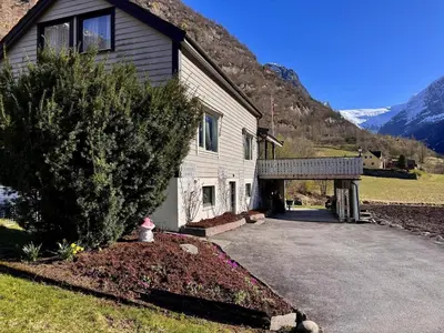 a house with a driveway next to a mountain at 4 bedroom house in beautiful Oldedalen in Stryn