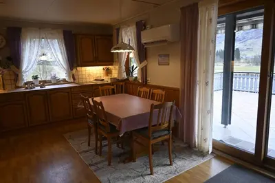a kitchen with a table and chairs and a kitchen with a porch at 4 bedroom house in beautiful Oldedalen in Stryn