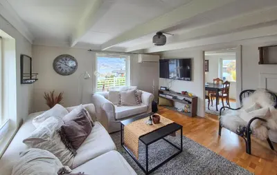 a living room with two couches and a clock on the wall at Pet Friendly Home In Nedre Vats in Åmsosen