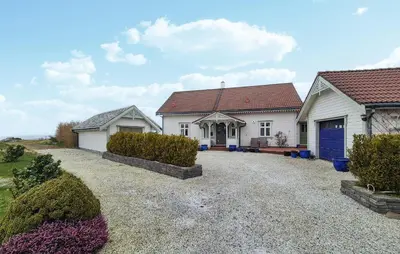 a white house with a blue door on a gravel driveway at Awesome Home In Bekkjarvik in Bekkjarvik