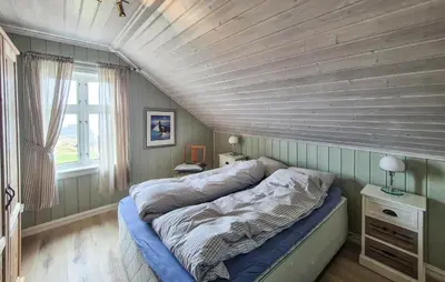 a bed in a room with a wooden ceiling at Awesome Home In Bekkjarvik in Bekkjarvik
