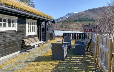 a group of chairs sitting outside of a building at Lovely Home In Straumgjerde in Brunstad