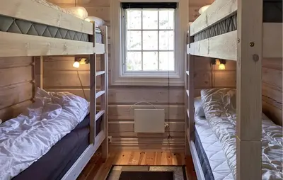 two bunk beds in a room with a window at Lovely Home In Straumgjerde in Brunstad