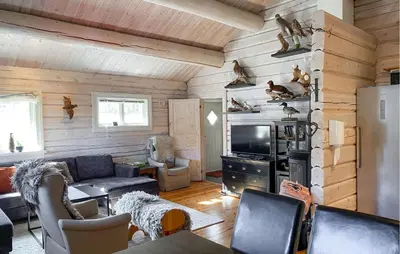 a living room with a couch and a tv at Lovely Home In Straumgjerde in Brunstad