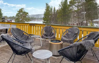 a group of chairs and a table on a deck at Beautiful Home In Bjorli With Wifi in Bjorli