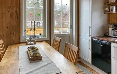 a kitchen with a wooden table with chairs and windows at Beautiful Home In Bjorli With Wifi in Bjorli