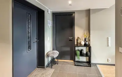 a hallway with a black door and a stool at 2 Bedroom Awesome Apartment In Sjusjøen in Sjusjøen