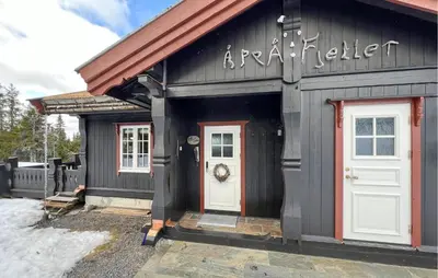 a black and white building with a white door at Nice Home In Sjusjøen With Wifi in Sjusjøen