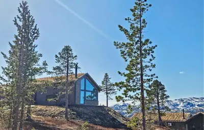 a house on top of a hill with trees at Beautiful Home In Tuddal With Wifi in Tuddal
