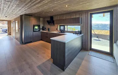 a kitchen with wooden walls and a large window at Beautiful Home In Tuddal With Wifi in Tuddal