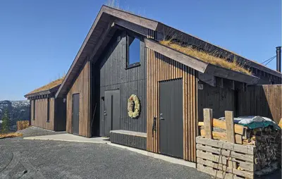 a black barn with a grass roof and a door at Beautiful Home In Tuddal With Wifi in Tuddal