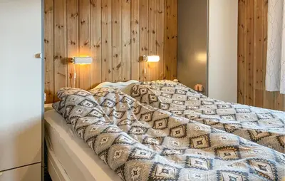 a bedroom with a bed with a comforter on it at Gorgeous Home In Oppdal With Wifi in Oppdal