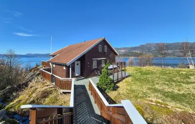 a house on a hill next to a lake at 4 Bedroom Stunning Home In Hebnes in Hebnes