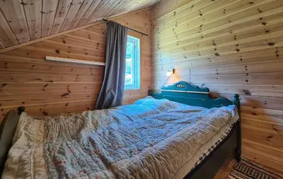 a bedroom with a blue bed in a log cabin at 4 Bedroom Stunning Home In Hebnes in Hebnes