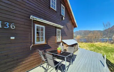 a table and chairs on a deck next to a house at 4 Bedroom Stunning Home In Hebnes in Hebnes