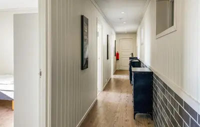 a hallway with white walls and a hallway with a table at 5 Bedroom Beautiful Home In Kverva in Kverva