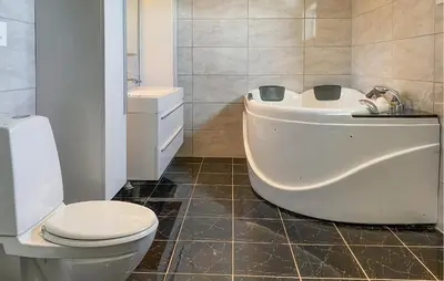 a bathroom with a white tub and a toilet at 5 Bedroom Beautiful Home In Kverva in Kverva