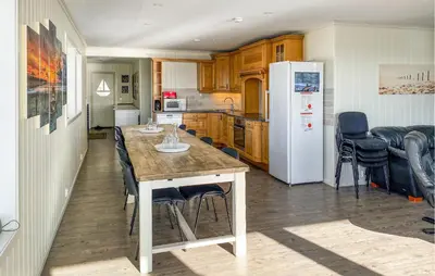 a kitchen with a table and chairs and a refrigerator at 5 Bedroom Beautiful Home In Kverva in Kverva