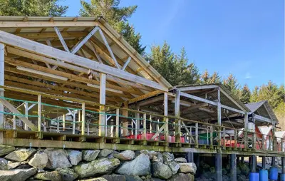 a house with a wooden roof over a stone wall at Gorgeous Home In Kverva With Wifi in Kverva