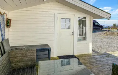a white house with a table and a door at Gorgeous Home In Kverva With Wifi in Kverva