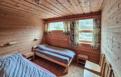 a log cabin with two beds and a window at Lovely Home In Masfjordnes With Sauna in Masfjorden