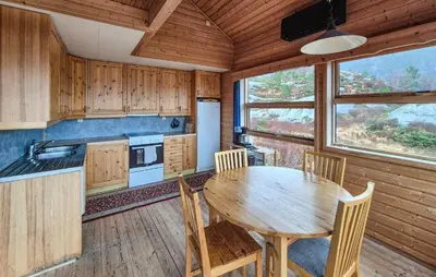a kitchen with a table and chairs in a cabin at Cozy Home In Masfjordnes With Sauna in Masfjorden
