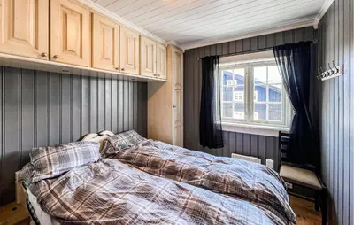 a bedroom with a bed with a comforter and a window at Stunning Apartment In Røn With Sauna in Ron