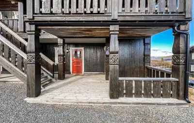 a wooden building with a red door and stairs at Stunning Apartment In Røn With Sauna in Ron